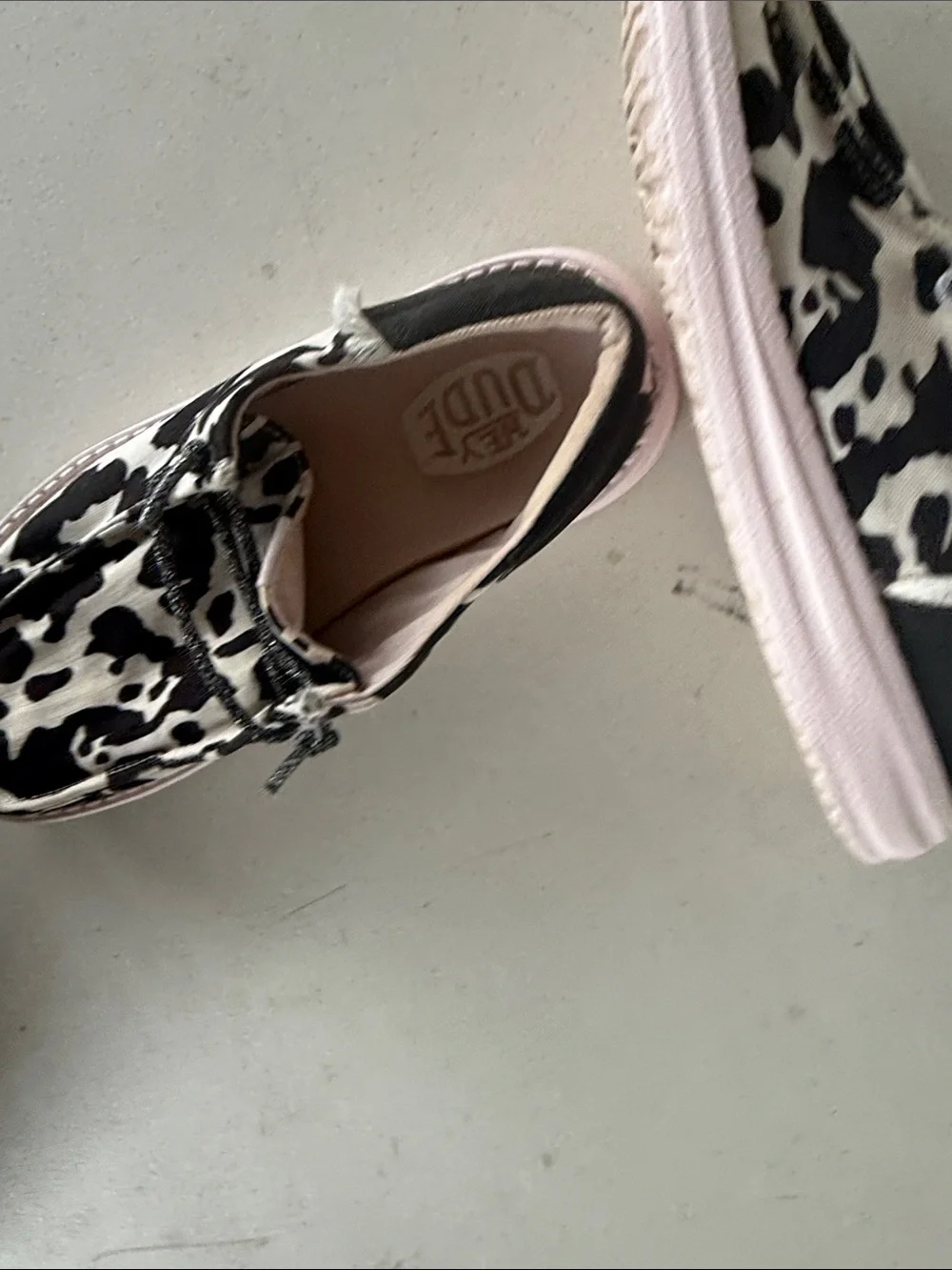 Hey Dude Kids Cow Print Slip-On Shoes in Black & White with Pink Trim